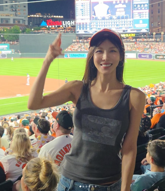 From Photograph to Leading Lady: Ha Ji-won Shows Us Sporty Confidence in Striped Tubes and Red Caps at the American Ballpark