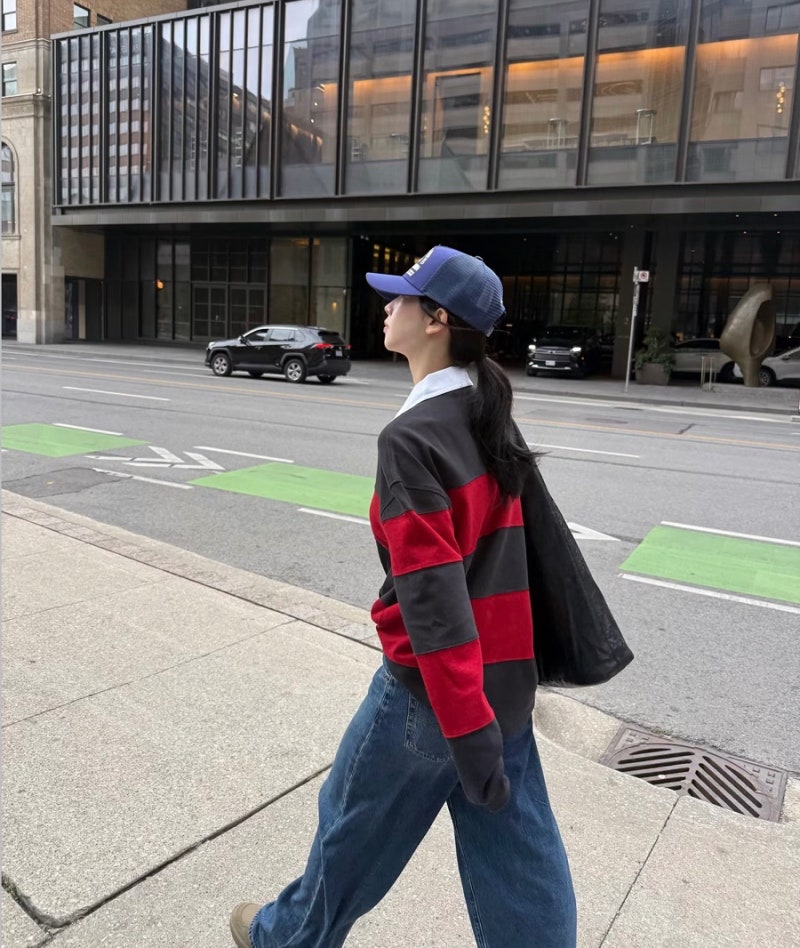 Karina looks cute in a rugby shirt and baseball cap... 'girlfriend look' fashion