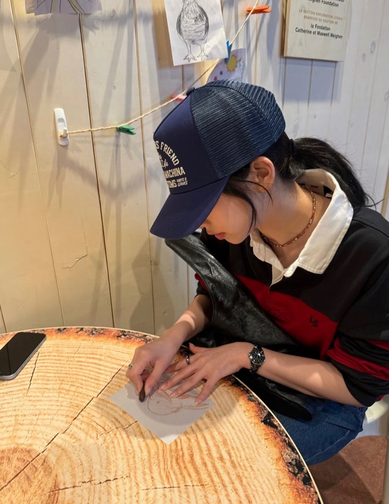 Karina looks cute in a rugby shirt and baseball cap... 'girlfriend look' fashion